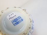 un vase bleu et blanc sur lequel est accrochée une étiquette