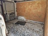 une photo d'une chambre en désordre avec un panier pour chien à l'intérieur