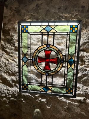 un vitrail orné d'une croix rouge