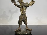 statue d'un homme tenant une épée et un oiseau, posée sur une table
