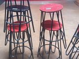 four stools and a table in a room with a red wall