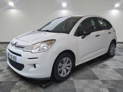 la petite voiture blanche est garée sur un carrelage à carreaux