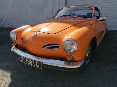 une voiture orange garée devant un immeuble