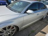 a silver car parked in a parking lot with other cars