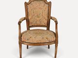 a wooden chair with a floral upholstered back and arms