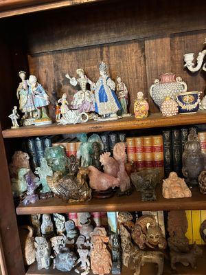 de nombreuses figurines sur les étagères de cette bibliothèque
