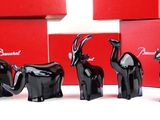 four black elephant figurines sitting in front of a red box