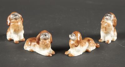 three small figurines of dogs sitting on a black surface
