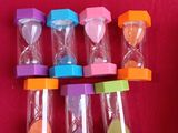 several hourglasss are arranged in a row on a red cloth