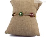 an image of a cushion with a pillow and a bracelet on it