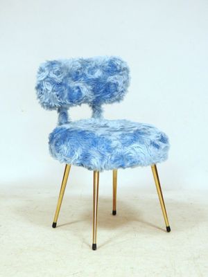 a blue chair with a gold legs on a white floor
