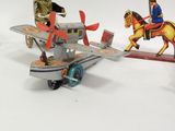 a small toy airplane with a man on a horse and a man on a horse on a plane