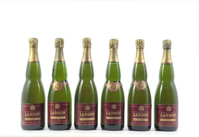 six bouteilles de vin sont alignées sur une surface blanche