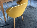 two yellow chairs sitting at a table with a laptop on it