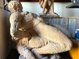 a statue of a man and a woman sitting on a shelf