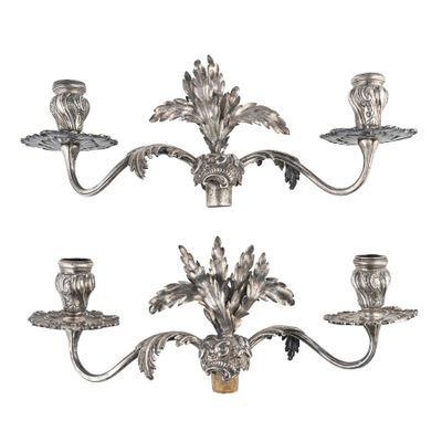 un ensemble de trois chandeliers en métal argenté ornés de fleurs et de feuilles