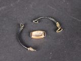 un bracelet avec un fermoir doré sur un fond noir
