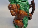 un petit singe en céramique avec un chapeau vert sur la tête