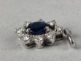 a close up of a sapphire and diamond broochle on a table