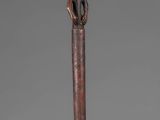 a close up of a wooden stick with a figure on it