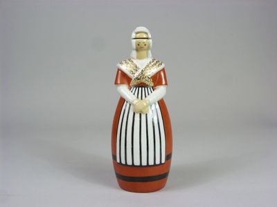 une figurine représentant une femme en robe et avec un chapeau