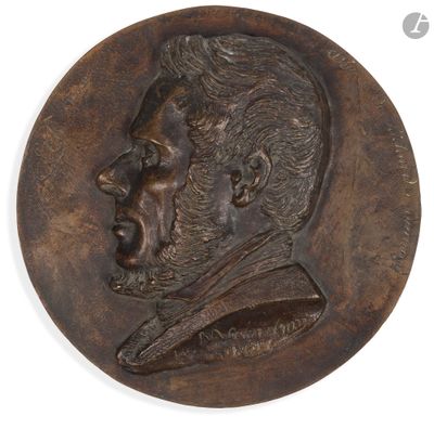 un gros plan sur un médaillon en bronze représentant le visage d'un homme