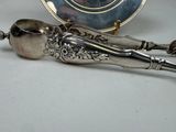 a silver spoon and spoon rest on a table next to a plate