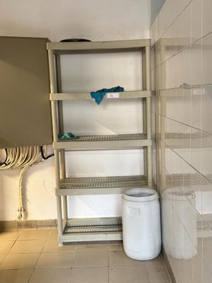 une poubelle blanche dans un coin de la salle de bains