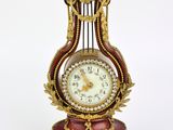 a clock that is sitting on a stand on a white surface