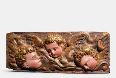 trois têtes de chérubins sur un morceau de bois