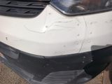 le pare-chocs avant d'une voiture blanche présentant une bosse