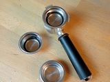 three cups and a coffee grinder on a wooden table
