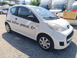 a small white car that is parked in a lot