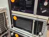 trois micro-ondes empilés les uns sur les autres dans un entrepôt