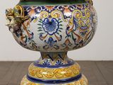 a vase that has a lid on it on a wooden table