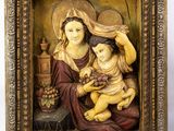 a statue of a woman holding a child in a frame