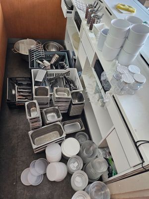 a kitchen with a lot of dishes and pans on the counter