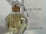 un flacon de parfum orné d'un oiseau, à côté d'une boîte