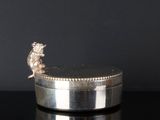 une assiette ancienne en argent, ornée d'un lion sur fond noir