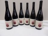 six bottles of wine are lined up on a table
