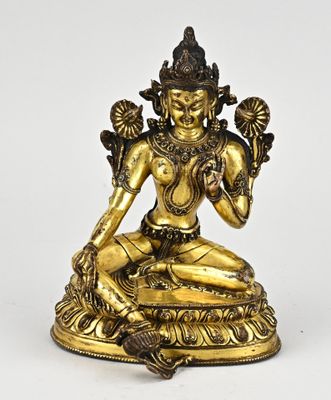 a gold statue of a woman sitting on a lotus