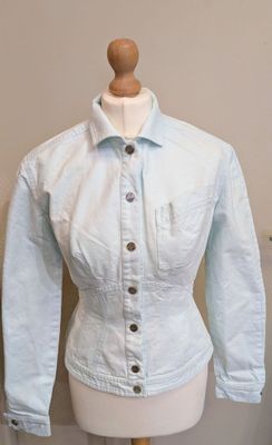 un mannequin vêtu d'une chemise bleu clair, posé sur un pied de mannequin