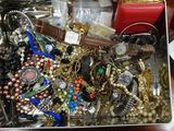 une boîte en métal remplie de bijoux variés, posée sur une table