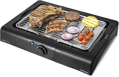 un grill avec de la viande et des légumes dessus, posé sur une table
