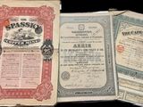 trois vieux certificats en papier sont posés sur une surface noire
