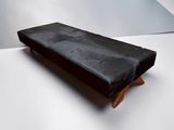 un banc noir posé sur une surface blanche