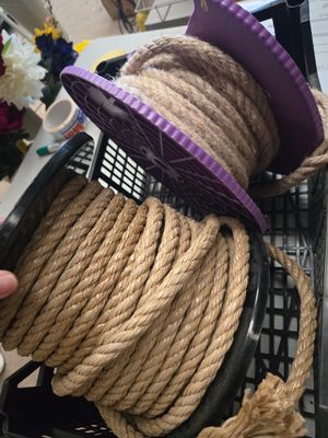 une corde enroulée autour d'un clavier d'ordinateur, sur lequel est posé un chapeau violet