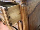 a wooden dresser with a drawer on top of it
