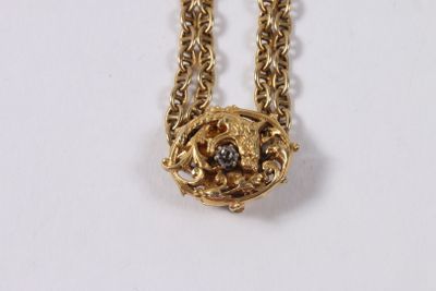 collier plaqué or avec des pierres noires et blanches sur une chaîne