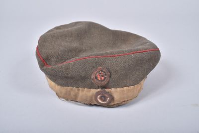 un chapeau orné d'un bouton sur un fond blanc